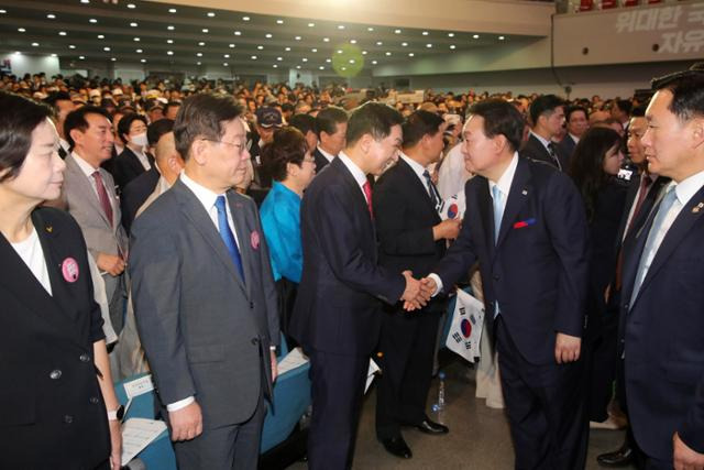 윤석열 대통령이 15일 오전 서울 서대문구 이화여대 대강당에서 열린 제78주년 광복절 경축식을 마친 뒤 김기현 국민의힘 대표와 악수하고 있다. 뉴시스