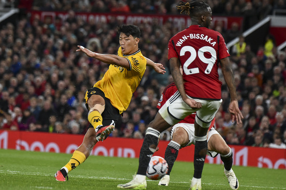 Wolverhampton Wanderers' Hwang Hee-chan, left, shoots during Wolves' first 2023-24 Premier League match against Manchester United at Old Trafford in Manchester, England on Monday. Although Wolves lost 1-0, Hwang put in a strong display and managed four shots. This season marks Hwang's third season at Wolves, having finished the 2022-23 season with three goals and one assist in the league. [AP/YONHAP]