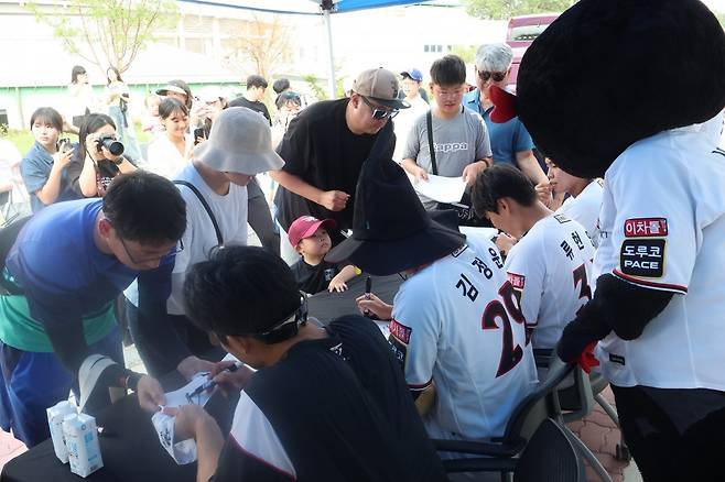 KT 위즈 팬들이 15일 전북 익산시에 위치한 국가대표 야구장에 방문해 경기 전 퓨처스군 선수들의 사인을 받는 모습. 사진제공 | KT 위즈