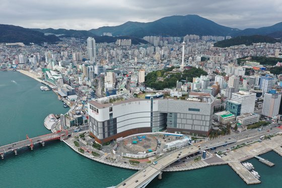 부산 중구 중앙동 옛 부산시청사 자리에 들어선 롯데백화점. 백화점 앞에 기초공사만 한 뒤 공사가 중단된 롯데타워 자리가 보인다. 송봉근 기자