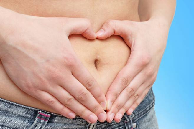 hands folded on his stomach in the form of a heart. on a blue background