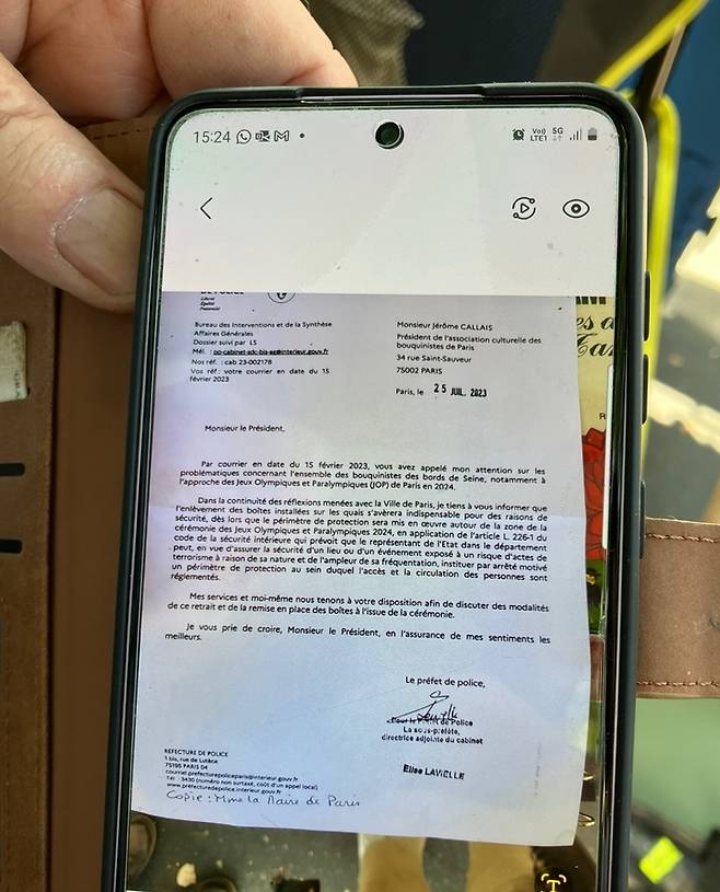 한 노천 서점 주인이 취재진에게 서점 철거 통보 내용이 담긴 파리 경찰청의 공문 사진을 보여주고 있다.