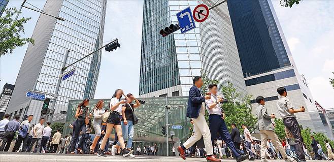 직장인들이 고층빌딩이 밀집한 서울 여의도 금융가를 지나가고 있다. 노동계가 법정 정년을 만 60세에서 65세로 늘리려 하는 가운데 대통령 직속 경제사회노동위원회는 20일 부정적 입장을 밝혔다.   한경DB