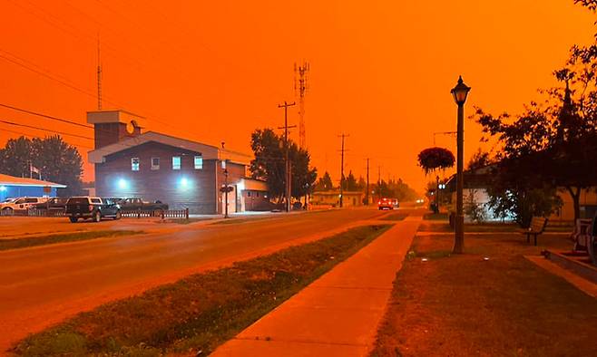 지난 13일(현지시간) 캐나다 노스웨스트 준주 포트스미스의 하늘이 산불로 인해 붉게 변한 모습. AFP연합뉴스