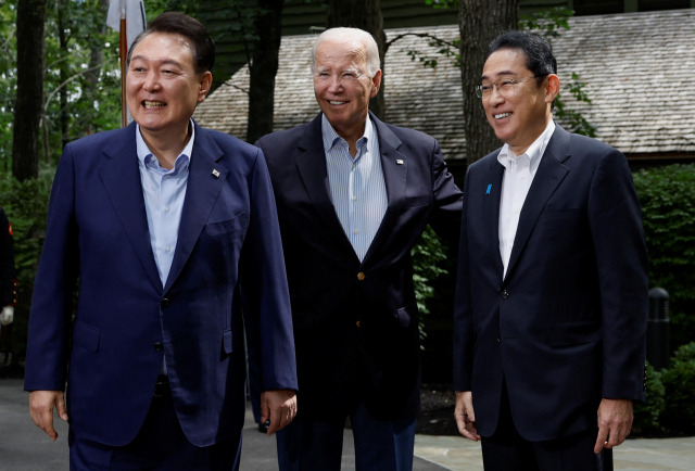 (왼쪽부터) 윤석열 대통령·조 바이든 미국 대통령·기시다 후미오 일본 총리가 18일(현지시간) 한미일 정상회의가 열린 미국 대통령 별장 캠프 데이비드에서 포즈를 취하고 있다. 세 정상은 이날 정상회의 후 공동기자회견에서 "한미일 관계의 새로운 장이 시작됐음을 선언한다"고 밝혔다. 캠프데이비드 로이터=연합뉴스