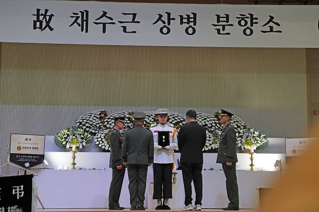 21일 경북 포항 해병대 1사단 내 체육관인 ‘김대식관’에 마련된 고 채수근 상병의 분향소에서 김계환 해병대 사령관(왼쪽 두번째)이 채 상병에게 수여할 훈장을 아버지(왼쪽 네번째)에게 전달하고 있다. (사진= 연합뉴스)