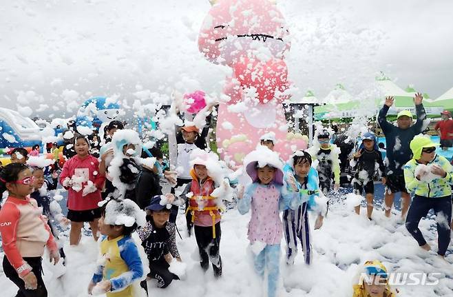 [부산=뉴시스] 하경민 기자 = 부산지역에 엿새째 폭염주의보 발효 중인 16일 남구 용호별빛공원에서 열린 '2023년 남구 물놀이 축제'를 찾은 어린이들이 인체에 무해한 거품 눈을 맞고 있다. 2023.08.16. yulnetphoto@newsis.com