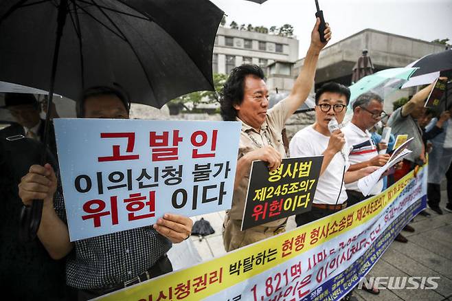 [서울=뉴시스] 정병혁 기자 = 지난 10일 서울 종로구 헌법재판소 앞에서 열린 "고발인에게 이의신청권리 박탈하는 현행 형사소송법 제245조의7, 제1항은 위헌이다" 기자회견에서 국민제안경연잔치 공동개최 추진회의 관계자들이 피켓을 들고 있다. 2023.08.10. jhope@newsis.com