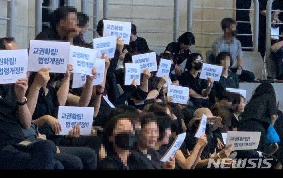 [청주=뉴시스] 김재광 기자 = 한국초등교장협의회가 주관한 '62회 한국초등교장협의회 하계 연수회'가 17일 청주의 한 체육관에서 열린 가운데 교장들이 '교권확립, 법령 개정' 문구가 적힌 손팻말을 들고 있다. 2023.08.17. kipoi@newsis.com