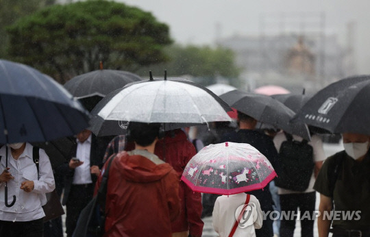 전국적으로 태풍 '카눈'의 영향으로 많은 비가 내린 지난 10일 서울 광화문네거리에 퇴근길 시민들이 우산을 쓰고 걸어가고 있다. [연합뉴스]