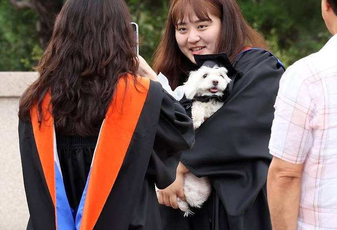 학사모를 쓴 강아지가 주인과 함께 졸업 기념촬영을 하고 있다. 사진=박범준 기자