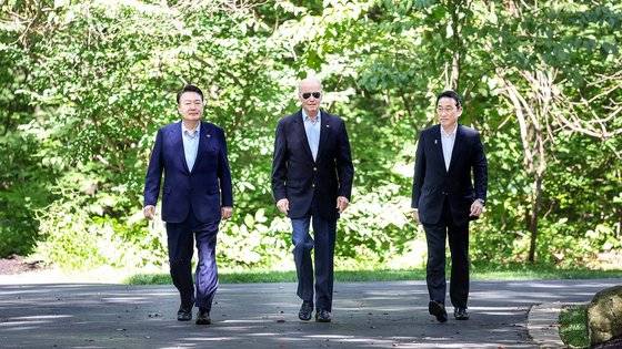 윤석열 대통령, 조 바이든 미국 대통령, 기시다 후미오 일본 총리가 지난 18일(현지시간) 워싱턴DC 인근 미국 대통령 별장인 캠프 데이비드에서 한미일 정상 공동기자회견을 위해 오솔길을 함께 걸어 오고 있다. 연합뉴스