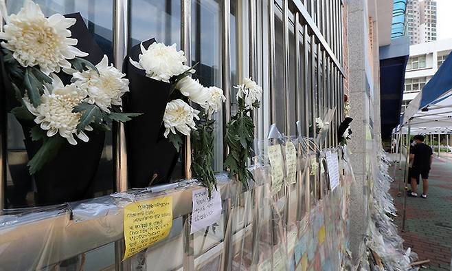 지난 7월 서울 서초구 서이초등학교를 찾은 시민들이 교내에서 극단 선택으로 숨진 교사를 위한 추모 메시지를 읽고 있다. 연합뉴스
