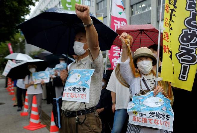 일본 시민들이 22일 도쿄 총리관저 앞에서 후쿠시마 제1원전에 보관 중인 오염수를 24일 방류할 것을 일본 정부가 결정한 것과 관련해 반대 집회를 하고 있다. 한 참여자가 ‘원전 오염수 독을 바다에 방류하지 말라’고 적힌 팻말을 들고 있다. 도쿄/AFP 연합뉴스