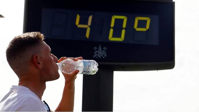 사진=겨울 온도가 40도를 기록한 가운데 한 남자가 물을 마시고 있다. (출처=에페)