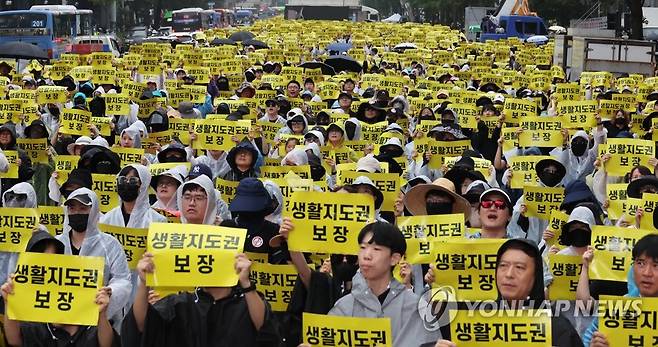 빗속, 구호 외치는 교사들 (서울=연합뉴스) 최재구 기자 = 12일 서울 종각역 인근 도로에서 열린 제4차 안전한 교육 환경을 위한 법 개정 촉구 집회에서 참여한 교사 등이 손팻말을 들고 구호를 외치고 있다. 2023.8.12 jjaeck9@yna.co.kr