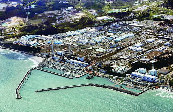 24일 방사성 물질 오염수 방류가 시작된 일본 후쿠시마현 후쿠시마 제1원자력발전소를 하늘에서 촬영한 모습. 2011년 3월11일 동일본대지진 때 일어난 사고로 노심용융이 일어나 다량의 방사성 물질이 유출된 원자로 뒤로 오염수를 보관한 물탱크들이 빼곡히 들어서 있다. 일본은 이날 오후 1시3분께부터 물탱크에 보관되어 있던 오염수를 원전 앞바다에 연결한 해저터널을 통해 방류하기 시작했다. 후쿠시마/교도 연합뉴스