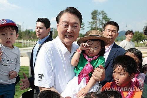 윤석열 대통령이 26일 서울 용산어린이정원 내 조성된 분수정원에서 열린 다둥이가족 초청행사에 깜짝 방문, 어린이들과 기념사진을 찍고 있다.  [대통령실 제공]