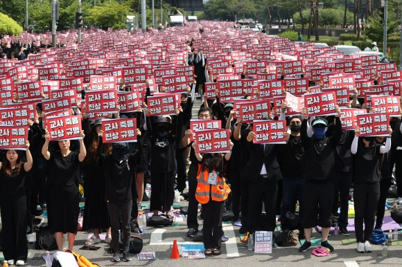 26일 오후 서울 영등포구 국회 앞에서 전국교사 일동이 연 ‘국회 입법 촉구 추모 집회’에서 참가자들이 손팻말을 들고 있다.  이들은 지난 7월 22일부터 매 주말 공교육 정상화와 지난달 사망한 서초구 초등학교 교사 사건의 진상 규명을 위한 집회를 열고 있다. 2023.8.26 연합뉴스