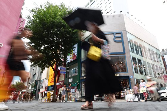 22일 서울 명동 상점가를 지나치는 시민들. 연합뉴스