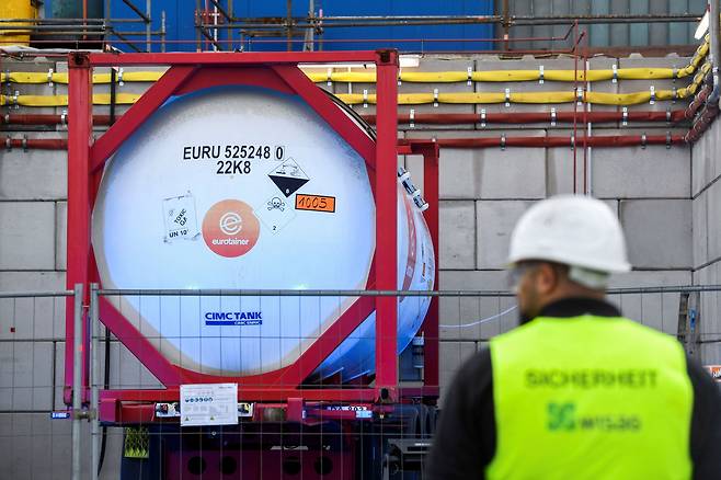 2022년 10월 21일 독일 함부르크 항구에서 아부다비 국영석유회사의 암모니아 수송선 첫 도착을 기념하는 공식 행사에 앞서 한 경비원이 독일에 본사를 둔 구리 회사 아우루비스의 탱크 컨테이너 앞에 서 있다. /로이터