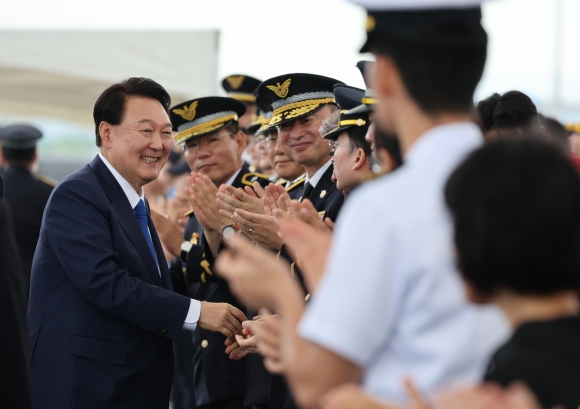 윤석열 대통령이 28일 인천 서구 아라서해갑문에서 열린 제70주년 해양경찰의 날 기념식에 입장하며 참석자들과 인사를 나누고 있다. 인천 연합뉴스