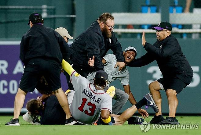 갑자기 구장에 난입한 팬에게 밀려 쓰러진 아쿠냐 주니어와 보안요원들 [USA 투데이/로이터=연합뉴스]