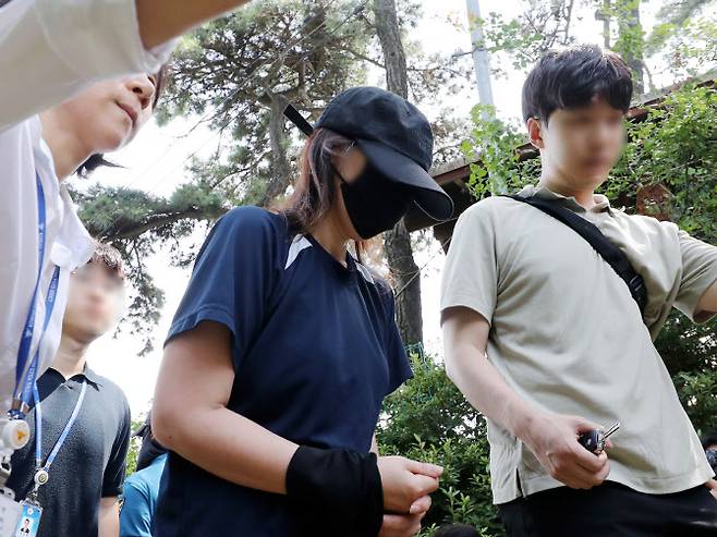 지난달 6일 오후 경기 김포시 대곶면 한 텃밭 입구에서 신생아 딸을 암매장한 혐의를 받는 40대 여성이 현장 검증을 마치고 이동하고 있다 (사진=연합뉴스)