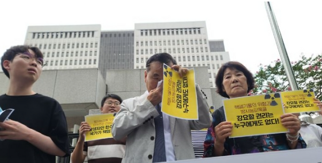 30일 오후 부산 연제구 부산고법 정문에서 갑상선암 공동소송 시민지원단 관계자가 기자회견에 앞서 땀을 닦고 있다. ⓒ뉴시스