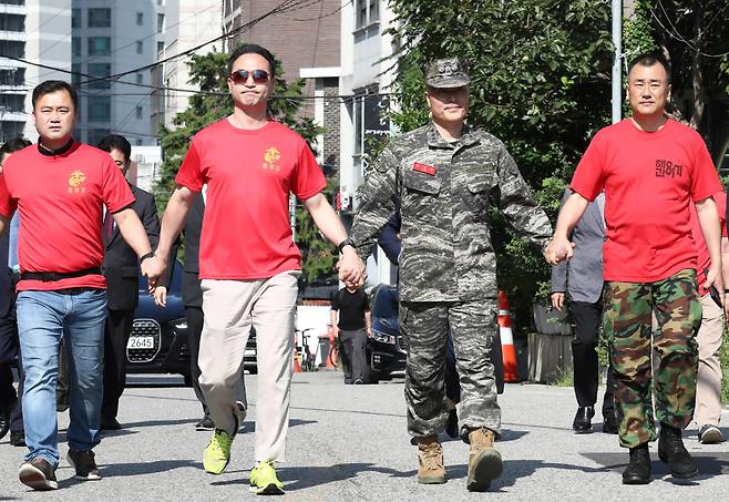 채아무개 상병 순직 사건을 수사하다 항명 등 혐의로 입건된 박정훈 전 해병대 수사단장이 9월1일 서울 용산구 군사법원에서 열린 구속 전 피의자심문(영장실질심사)에 출석하며 예비역 동기생들과 손을 잡고 있다. ⓒ 시사저널 임준선