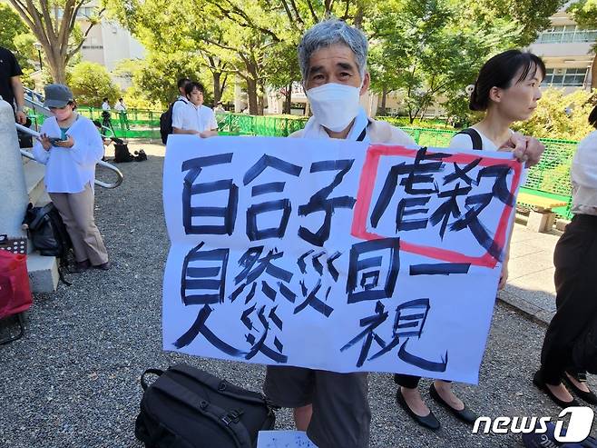 1일 도쿄도 스미다구 요코아미쵸 공원에서 한 집회자가 '유리코(도쿄 도지사) 자연재해와 학살을 동일시'라는 팻말을 들고 서 있다. 2023.09.01/ ⓒ 뉴스1 권진영 기자