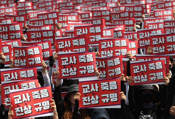 지난달 26일 오후 서울 영등포구 국회 앞에서 전국교사일동이 연 '국회 입법 촉구 추모집회'에서 참가자들이 손팻말을 들고 있다. 연합뉴스