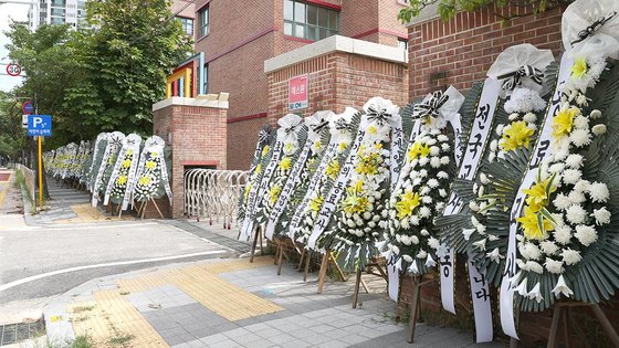 지난달 9일 경기도 의정부시의 한 초등학교에서 고인이 된 교사를 추모하는 화환이 줄지어 놓여 있다. 경기도교육청은 2년 전 이 초등학교 교사 2명이 잇따라 숨진 사고와 관련해 진상 조사를 벌이고 있다. 연합뉴스