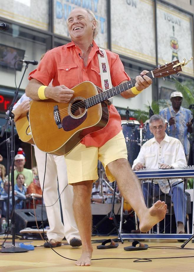 억만장자 기업가이자 가수인 지미 버핏이 2004년 6월 25일(현지시간) 미국 뉴욕 록펠러플라자에서 열린 NBC 투데이쇼 여름 콘서트에서 맨발로 기타를 치며 노래를 부르고 있다. CNN 등 외신에 따르면 지미 버핏은 1일 밤 76세를 일기로 별세했다. AP연합