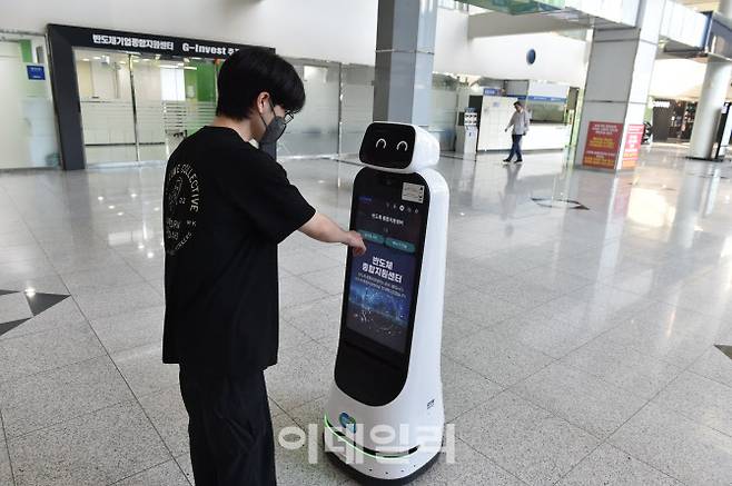 4일 광교테크노밸리 경기도경제과학진흥원 로비에서 내방객이 안내로봇 ‘광도리’를 통해 시설 위치를 파악하고 있다.(사진=경기도경제과학진흥원)