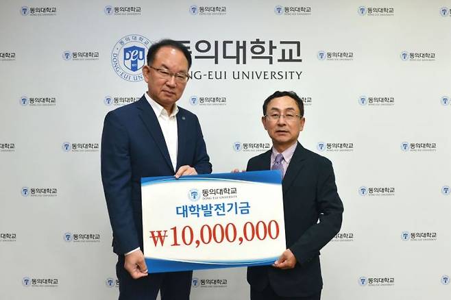 동의대 한수환 총장과 강정규 미래융합대학장이 발전기금 전달 기념사진을 찍고 있다.