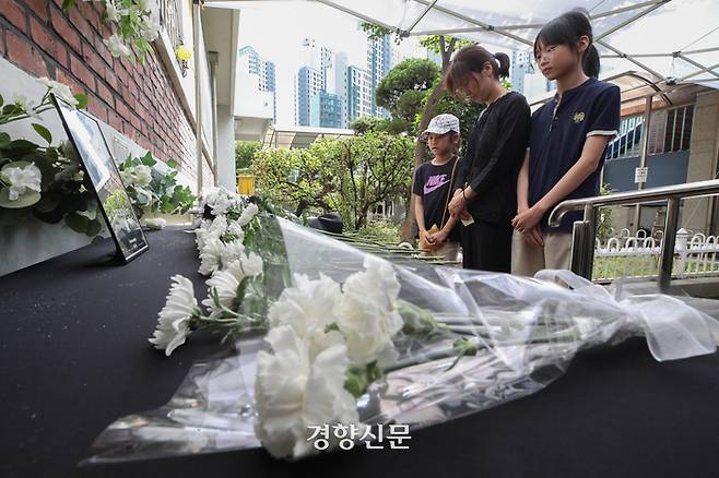 서울 서초구 한 초등학교 교사의 49재인 4일 교내에 마련된 추모공간을 찾은 학부모와 학생들이 헌화 후 묵념을 하고 있다. 성동훈 기자