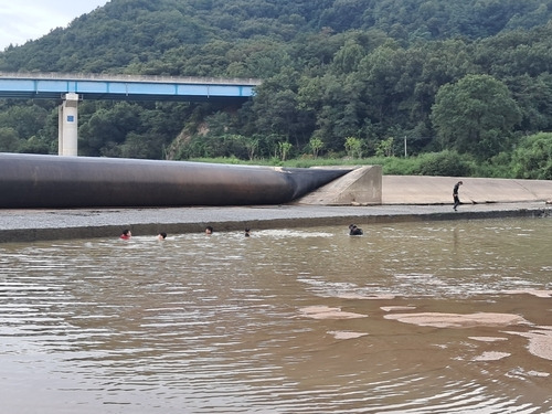 Fire authorities arrive at the scene of the accident and search for the missing person. (Yonhap)