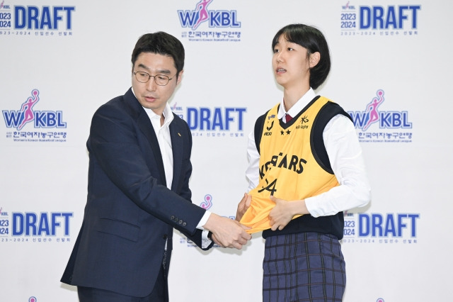 고현지(오른쪽)가 4일 충북 청주체육관에서 열린 2023-2024 WKBL 신입선수 선발회에서 전체 1순위로 KB 스타즈에 지명된 뒤 김완수 감독으로부터 유니폼을 받고 있다. WKBL 제공