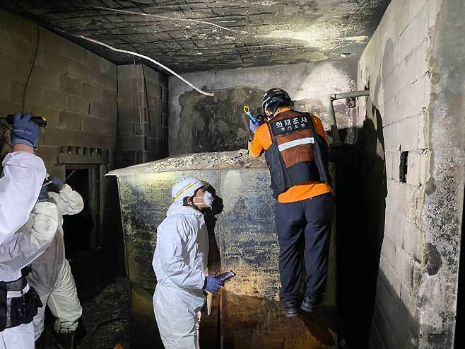 부산 동구 목욕탕 화재와 관련해 소방당국이 발화 지점으로 지목된 경유 연료탱크를 살피고 있다. 부산소방재난본부 제공