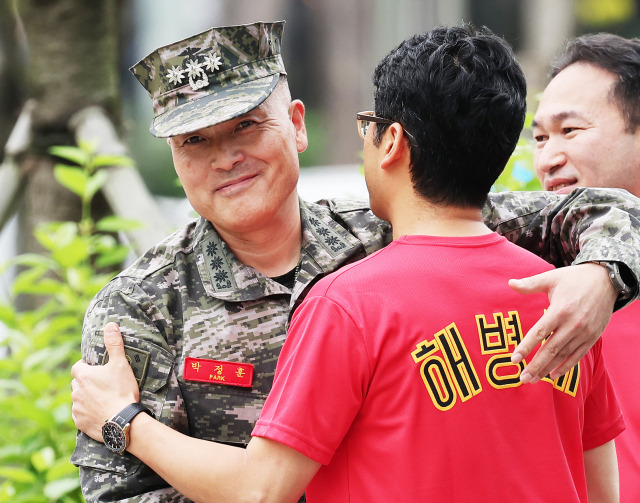 채 모 상병 순직 사건을 수사하다 해임된 박정훈 전 해병대 수사단장이 4일 오전 경기도 수원시 영통구 수원지방법원에서 열린 보직해임 집행정지 신청 첫 심문에 출석하며 전우들과 인사하고 있다. 연합뉴스