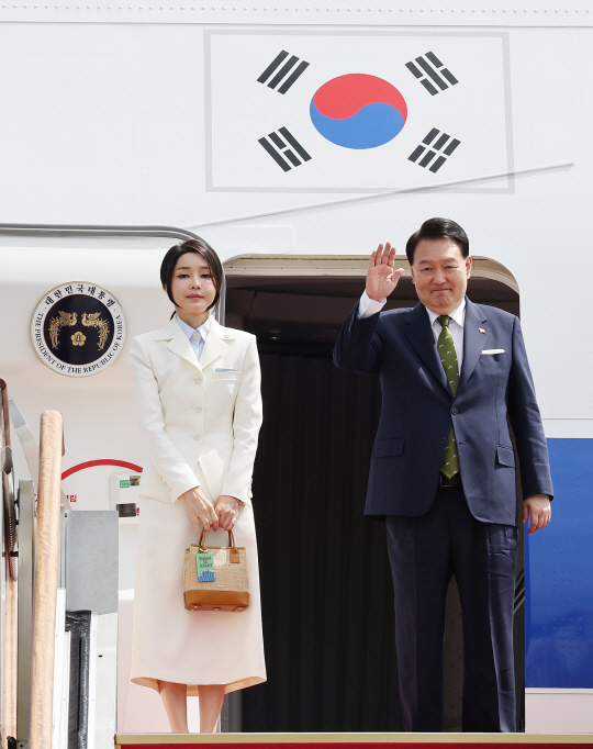 윤석열 대통령과 부인 김건희 여사가 5일 성남 서울공항에서 출국하며 전용기인 공군 1호기에 올라 환송객을 향해 손을 흔들고 있다. 연합뉴스