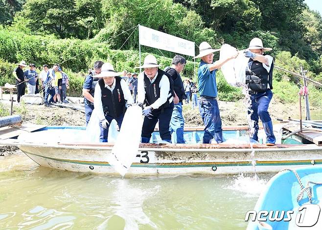 6일 파주 임진리 선착장에서 김경일 파주시장(왼쪽에서 2번째)과 어민들이 황복과 대농갱이 치어를 방류하고 있다. (파주시 제공)