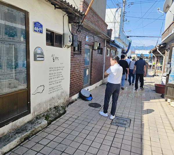 속초 아바이마을 골목을 걷고 있는 워크숍 일행이 벽을 장식한 가수 민승아의 노래 ‘실향민’ 가사를 보고 있다.