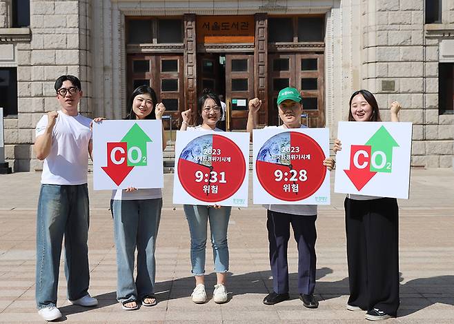 최열 환경재단 이사장(오른쪽 둘째)과 환경재단 직원들이 서울시청 앞에서  환경위기시계 퍼포먼스를 펼치고 있다.