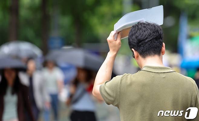 가을을 재촉하는 소나기가 내린 30일 서울 영등포구 여의도 일대에서 우산을 미처 챙기지 못한 시민들이 파일로 머리를 가린 채 발걸음을 재촉하고 있다. 2023.8.30/뉴스1 ⓒ News1 김성진 기자