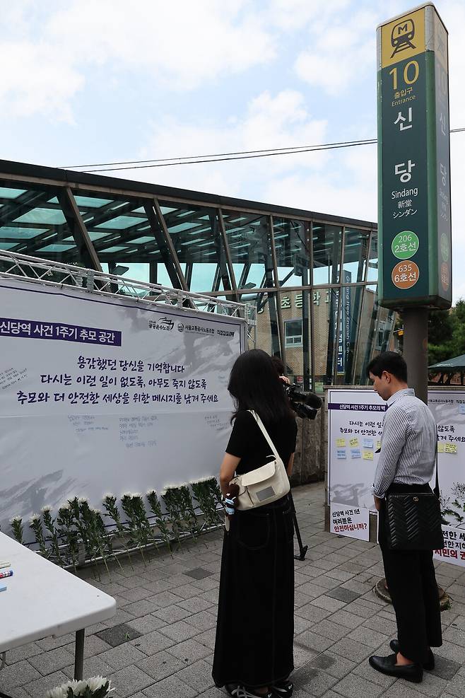 공공운수노조와 서울교통공사노조, 직장갑질119 관계자들이 11일 오전 서울 중구 신당역 10번 출구 앞에 마련된 신당역 스토킹 살인사건 피해자 1주기 추모공간에 헌화한 뒤 묵념하고 있다. 백소아 기자