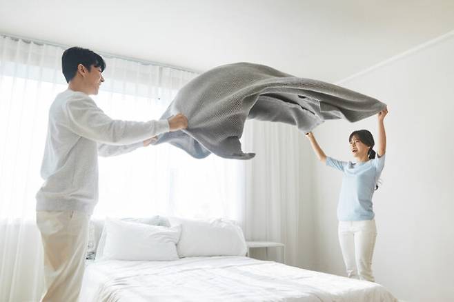 아침에 잠이 덜 깬 상태에서 이불을 탈탈 털고 베개를 툭툭쳐서 모양을 잡는 일이 실제로 호흡-기관지 건강에 해를 끼칠 수 있다고 최근 영국 일간 더썬(thesun)이 소개했다. [사진=게티이미지뱅크]