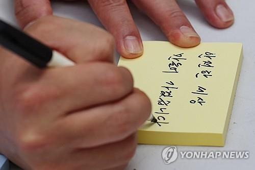 신당역 살인사건 추모공간에서 적는 메시지 (서울=연합뉴스) 신현우 기자 = 11일 서울 지하철 신당역 10번 출구 인근에 마련된 '신당역 스토킹 살인사건' 1주기 추모공간에서 공공운수노조 관계자가 추모 메시지를 적고 있다. 2023.9.11 nowwego@yna.co.kr