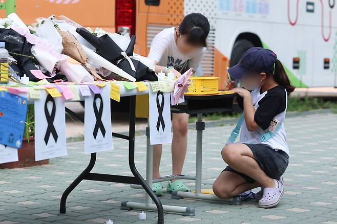 지난 7월 21일 오전 어린이들이 서울 서초구 서이초등학교에서 고인이 된 서이초등학교 담임교사 A씨 추모공간에 메모를 남기고 있다. /연합뉴스